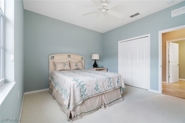 carpeted bedroom with ceiling fan and a closet