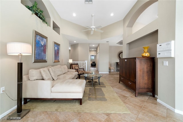 tiled living room featuring ceiling fan and high vaulted ceiling