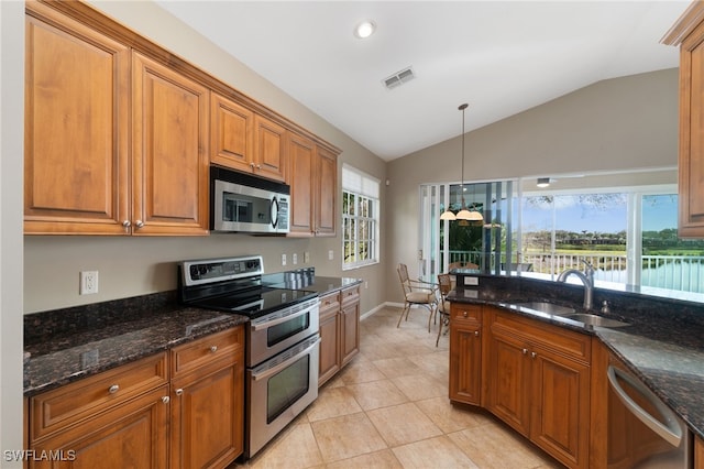 kitchen featuring appliances with stainless steel finishes, pendant lighting, plenty of natural light, and lofted ceiling