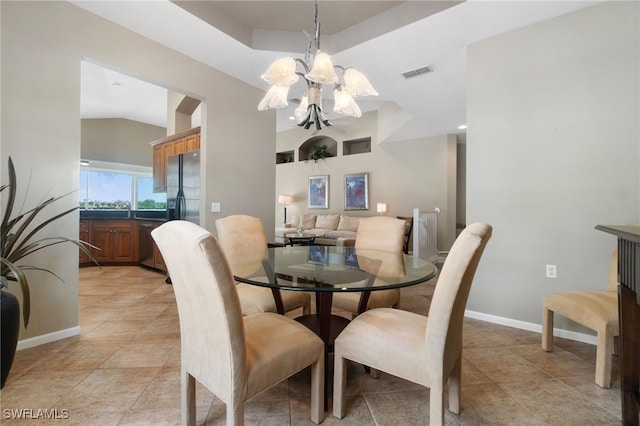 dining space featuring a chandelier, light tile patterned floors, vaulted ceiling, and sink