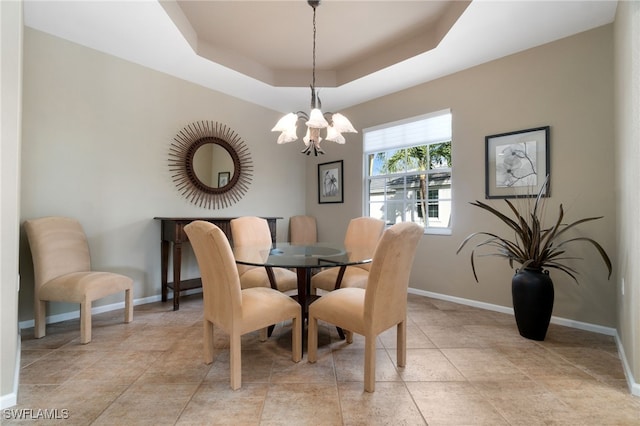 dining room featuring a tray ceiling and a notable chandelier