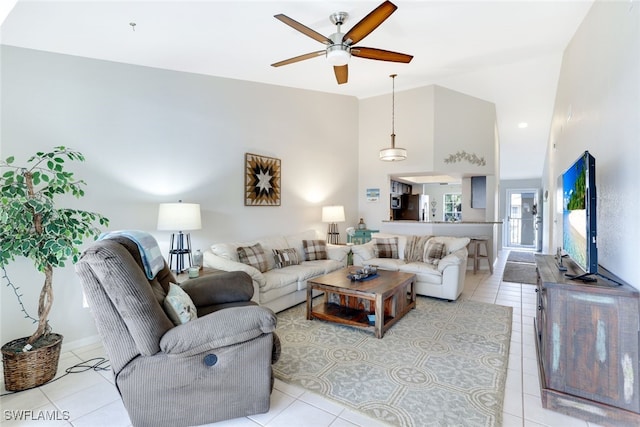 living room featuring ceiling fan, light tile patterned floors, and a high ceiling