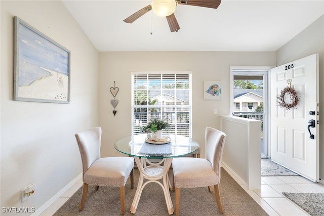 tiled dining area with vaulted ceiling, ceiling fan, and a healthy amount of sunlight