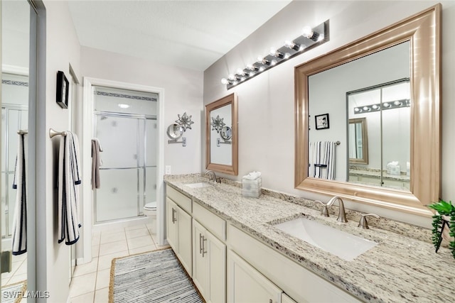 bathroom featuring tile patterned floors, toilet, vanity, and walk in shower