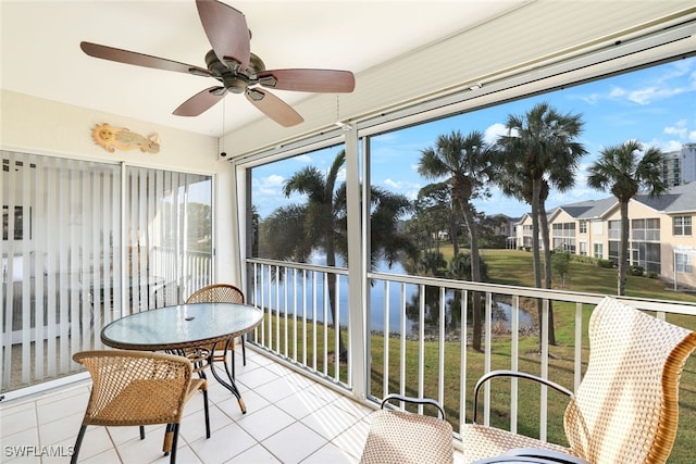 sunroom / solarium featuring a water view and ceiling fan