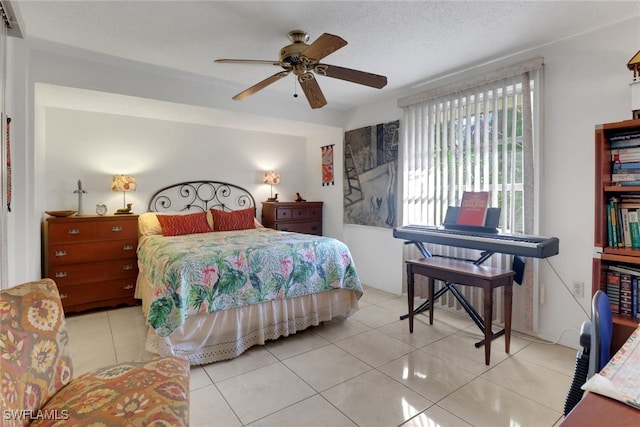 bedroom with a ceiling fan, a textured ceiling, and tile patterned floors