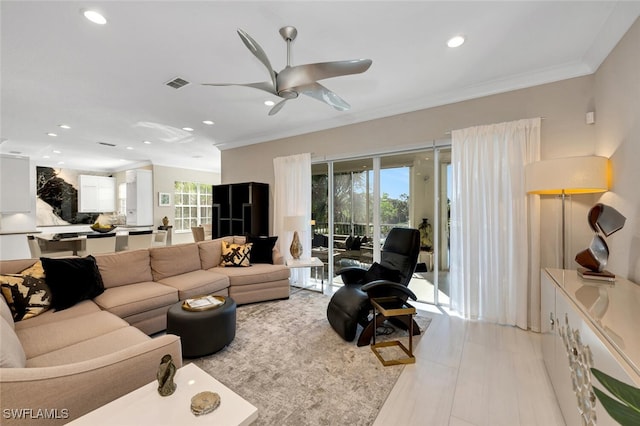 living room featuring ceiling fan, light tile patterned flooring, and crown molding