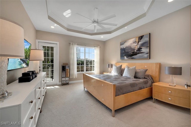 carpeted bedroom featuring a tray ceiling, ceiling fan, and crown molding