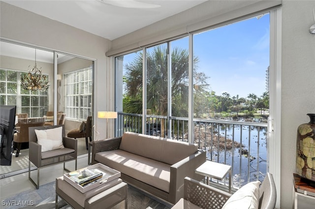 sunroom with a water view and a chandelier