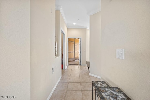 hallway with ornamental molding and light tile patterned flooring