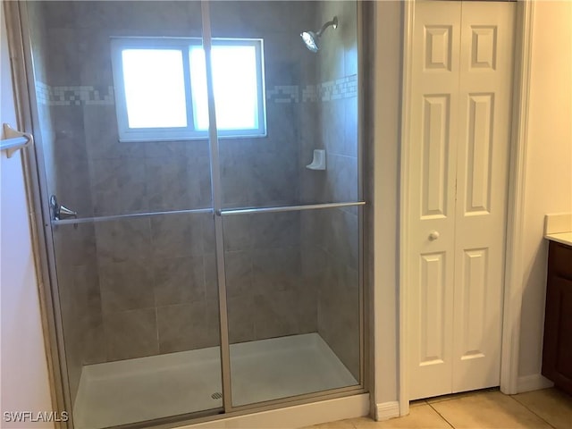 bathroom featuring tile patterned flooring, vanity, and a shower with door