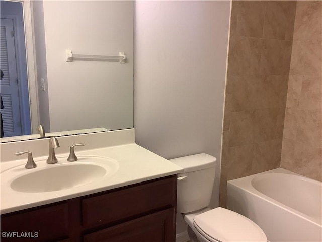 full bathroom featuring vanity, tiled shower / bath combo, and toilet