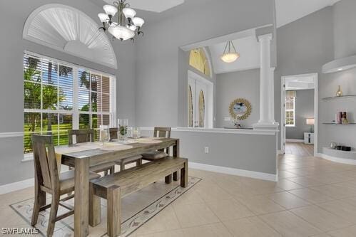 dining space featuring an inviting chandelier, vaulted ceiling, built in features, ornate columns, and light tile patterned floors