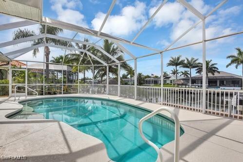 view of swimming pool featuring a lanai and a patio area