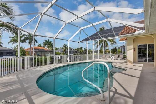 view of swimming pool featuring a patio area and a lanai