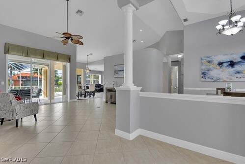 interior space with ornate columns, high vaulted ceiling, and ceiling fan with notable chandelier