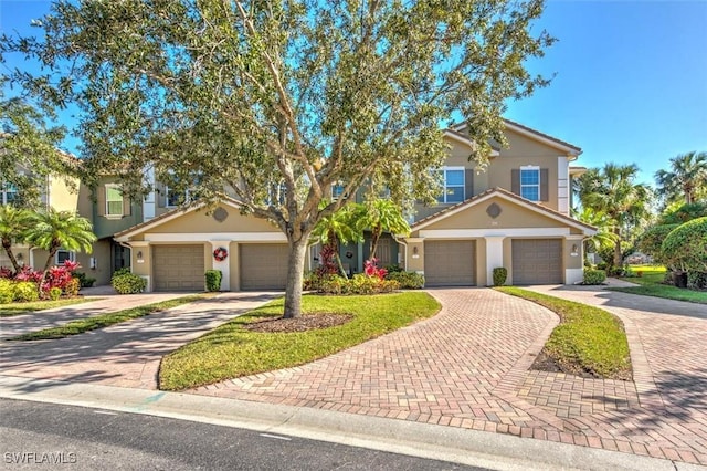 view of front of home featuring a garage, driveway, and stucco siding