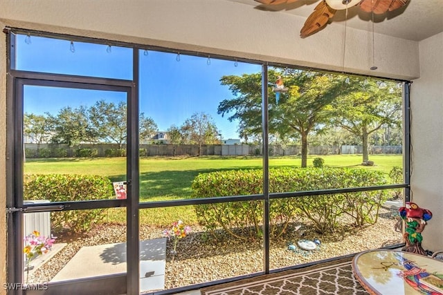 unfurnished sunroom featuring a ceiling fan