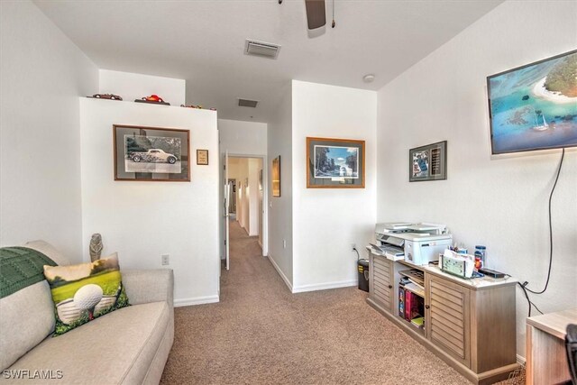 living room with light carpet, baseboards, visible vents, and ceiling fan