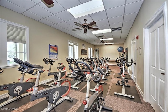 workout area featuring a paneled ceiling, plenty of natural light, and ceiling fan