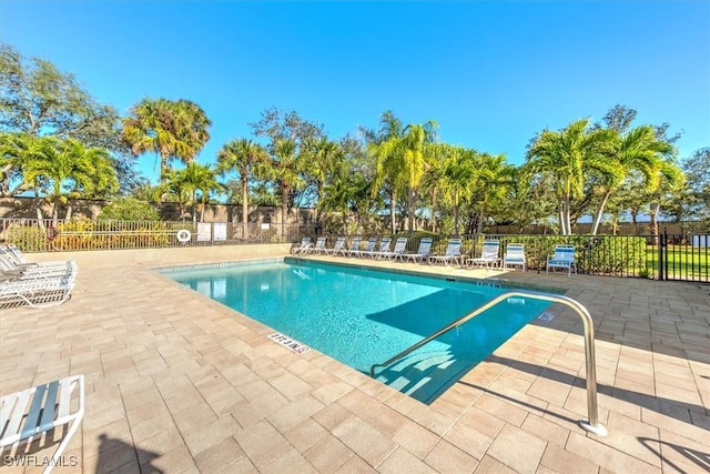 pool with a patio area and fence