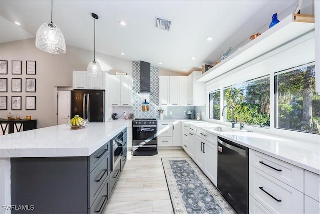 kitchen with white cabinets, stainless steel appliances, and vaulted ceiling