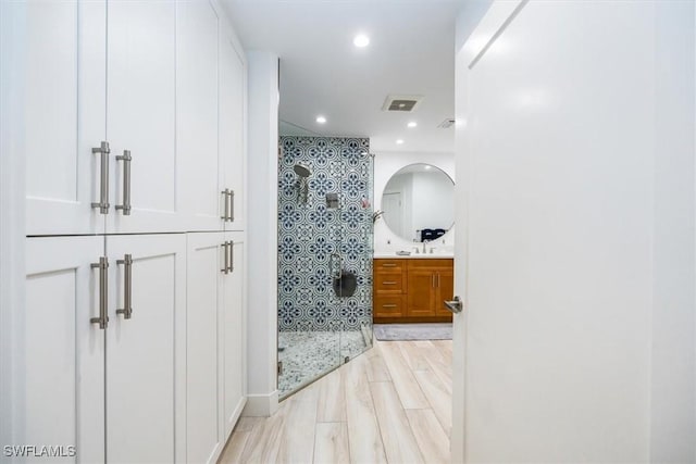 bathroom with hardwood / wood-style flooring and walk in shower