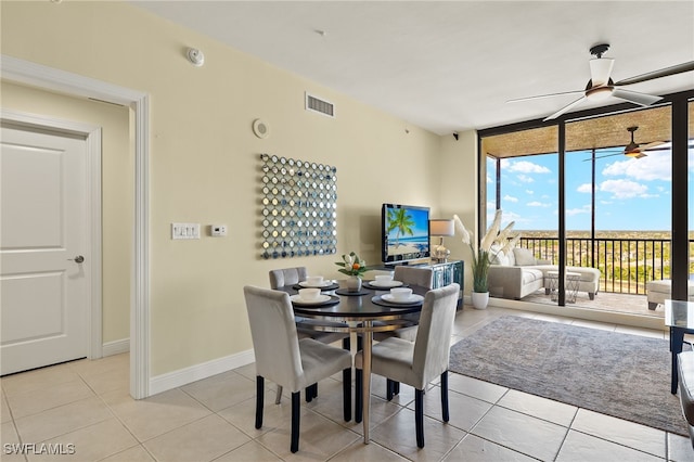 tiled dining room featuring a wall of windows and ceiling fan