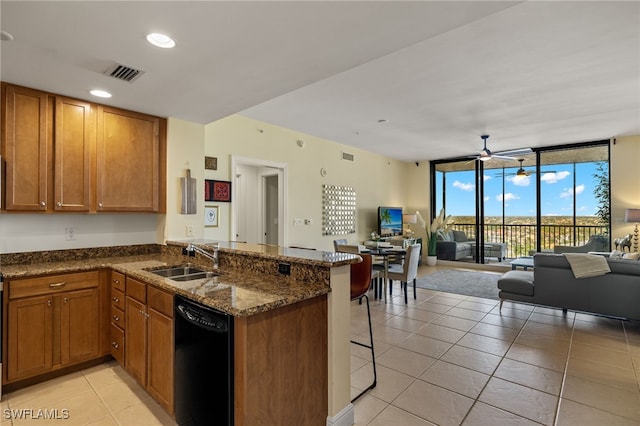 kitchen featuring kitchen peninsula, sink, a wall of windows, black dishwasher, and a breakfast bar area