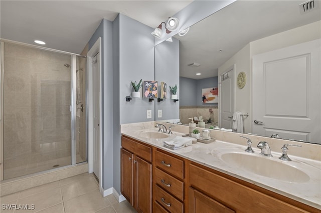 bathroom with tile patterned floors, vanity, and a shower with door