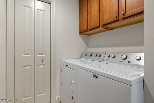 washroom featuring cabinets and washing machine and dryer