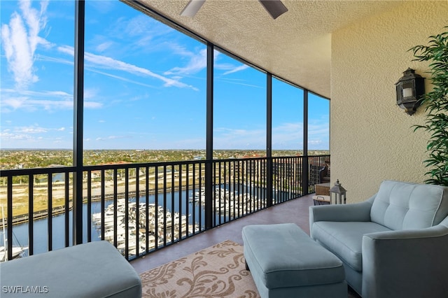 sunroom with a water view and ceiling fan