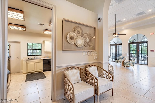 interior space featuring french doors, a raised ceiling, ceiling fan, sink, and light tile patterned flooring