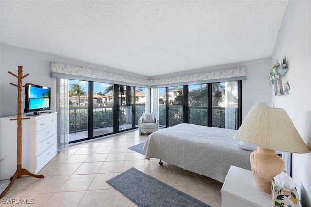 tiled bedroom with access to exterior and a textured ceiling