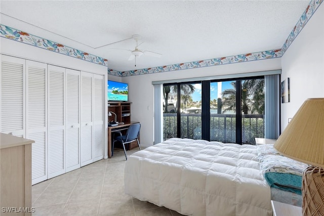 tiled bedroom featuring ceiling fan, a textured ceiling, and a closet