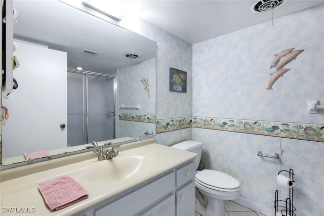 bathroom with vanity, toilet, tile walls, and a shower with shower door