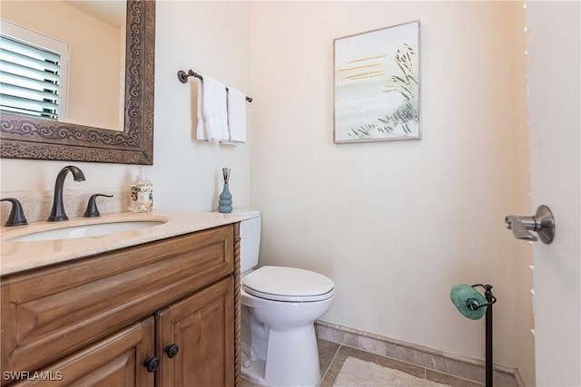 bathroom featuring tile patterned flooring, vanity, and toilet