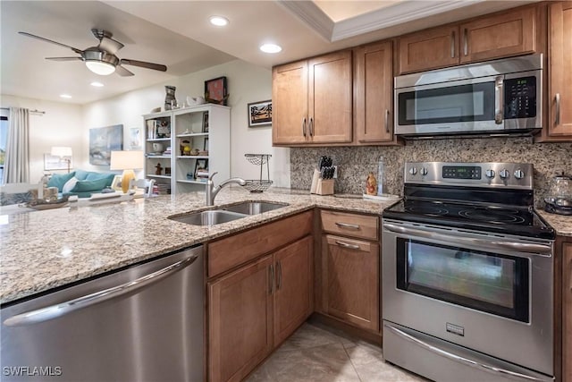 kitchen with light stone countertops, tasteful backsplash, stainless steel appliances, crown molding, and sink