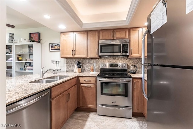 kitchen featuring sink, stainless steel appliances, tasteful backsplash, kitchen peninsula, and a tray ceiling