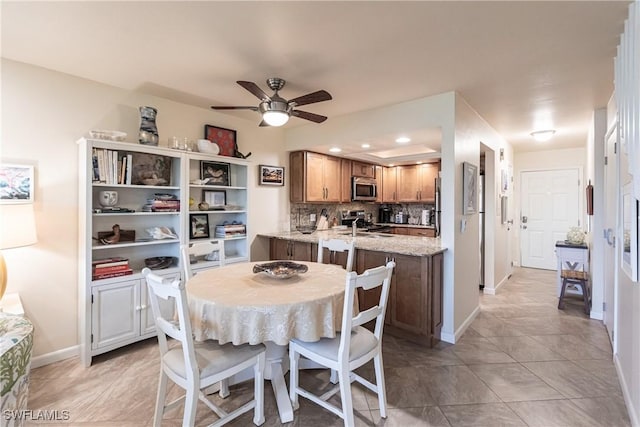 tiled dining space with ceiling fan