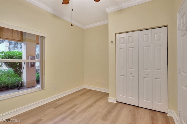 unfurnished bedroom featuring baseboards, light wood-style flooring, ceiling fan, a closet, and crown molding