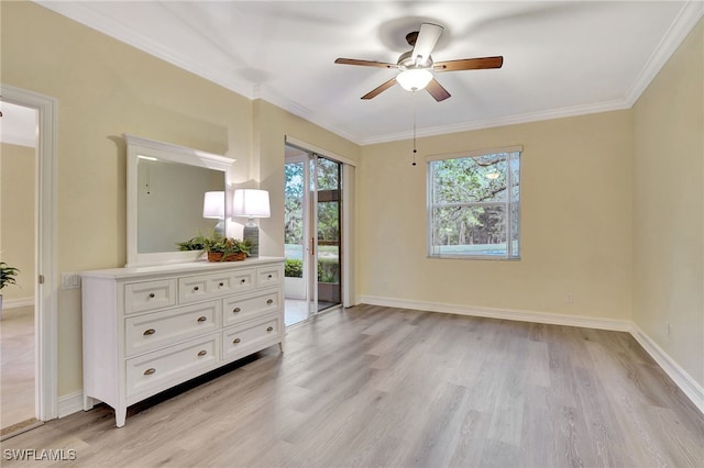 empty room featuring a ceiling fan, crown molding, light wood-style floors, and baseboards