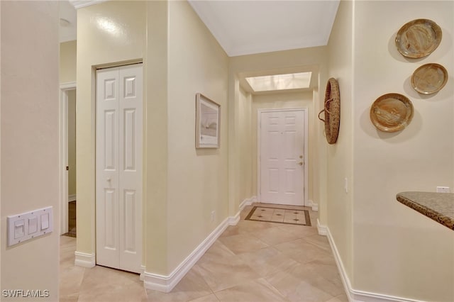 hallway featuring light tile patterned floors and baseboards