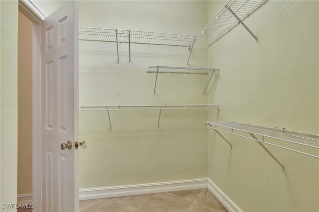 walk in closet with light tile patterned floors