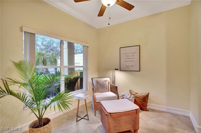 living area featuring crown molding, a ceiling fan, and baseboards