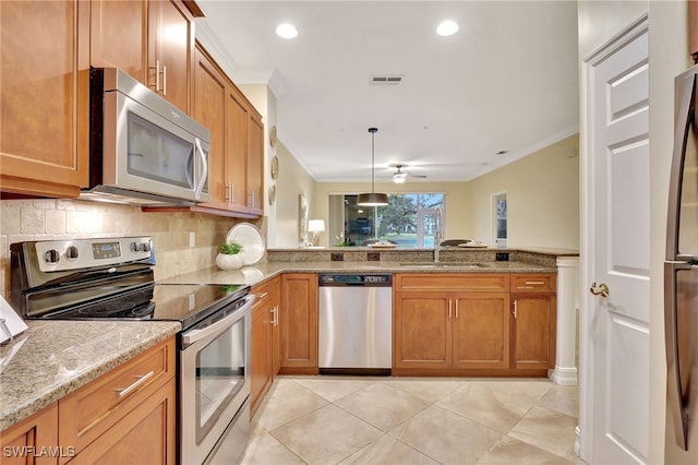 kitchen featuring a sink, stainless steel appliances, ornamental molding, and brown cabinetry