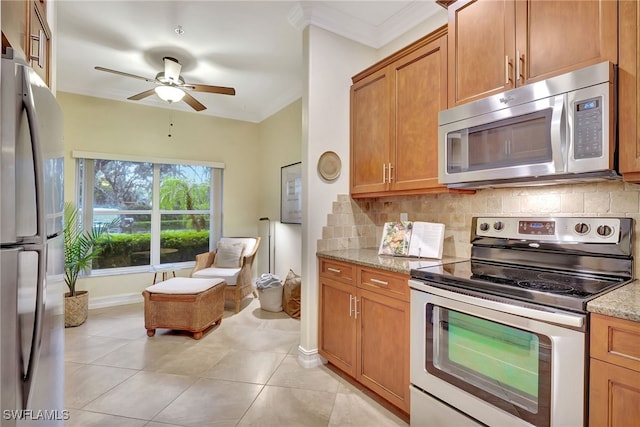 kitchen featuring tasteful backsplash, light stone countertops, appliances with stainless steel finishes, and light tile patterned floors