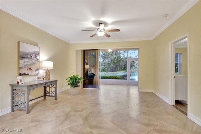 interior space with baseboards, a ceiling fan, and crown molding