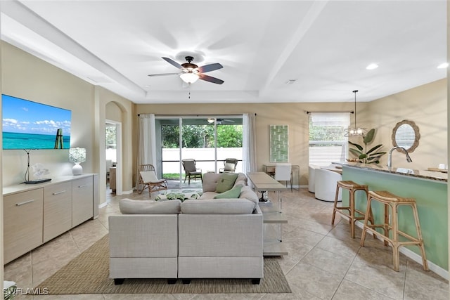 living room with light tile patterned floors and ceiling fan with notable chandelier