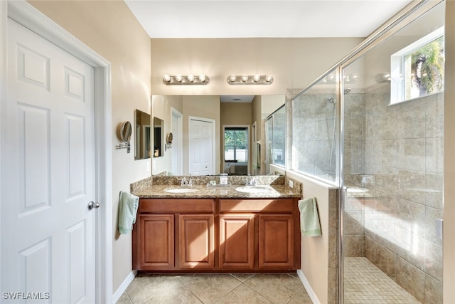 bathroom featuring a wealth of natural light, tile patterned flooring, vanity, and walk in shower